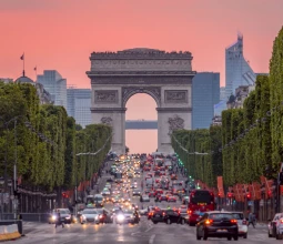 Champs Elysees und der Arc de Triomphe bei einem rosa Sonnenuntergang.